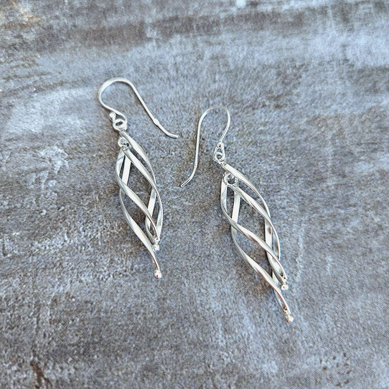 Silver earrings on a textured gray surface