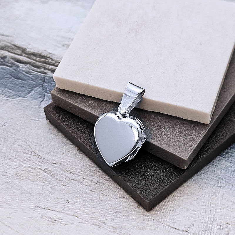 Silver heart-shaped pendant on a textured surface