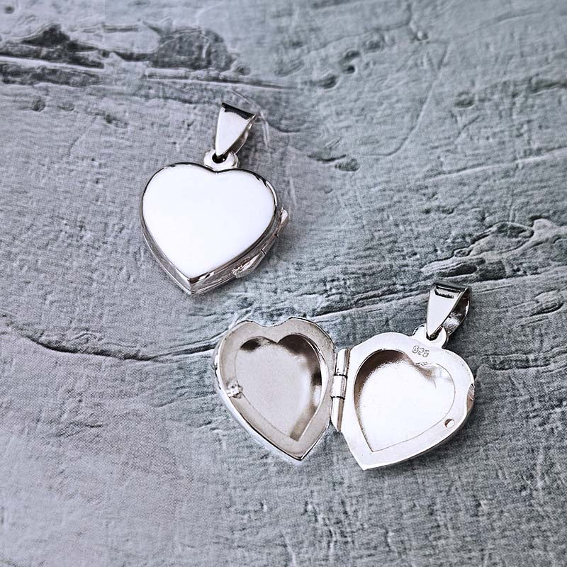Heart-shaped silver locket on a textured gray surface
