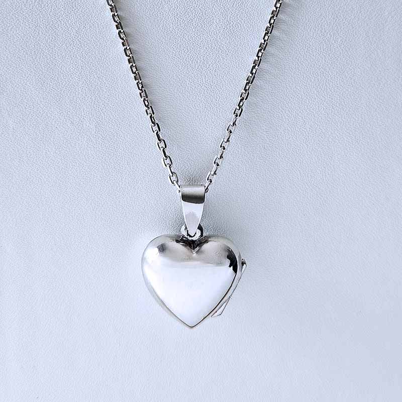Silver heart-shaped pendant on a chain against a light gray background