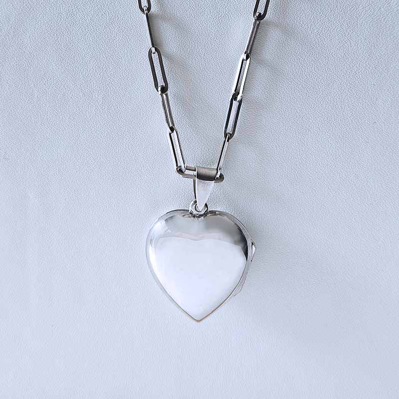 Heart-shaped pendant on a chain against a light gray background