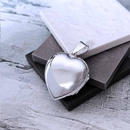 Silver heart-shaped pendant on a textured surface