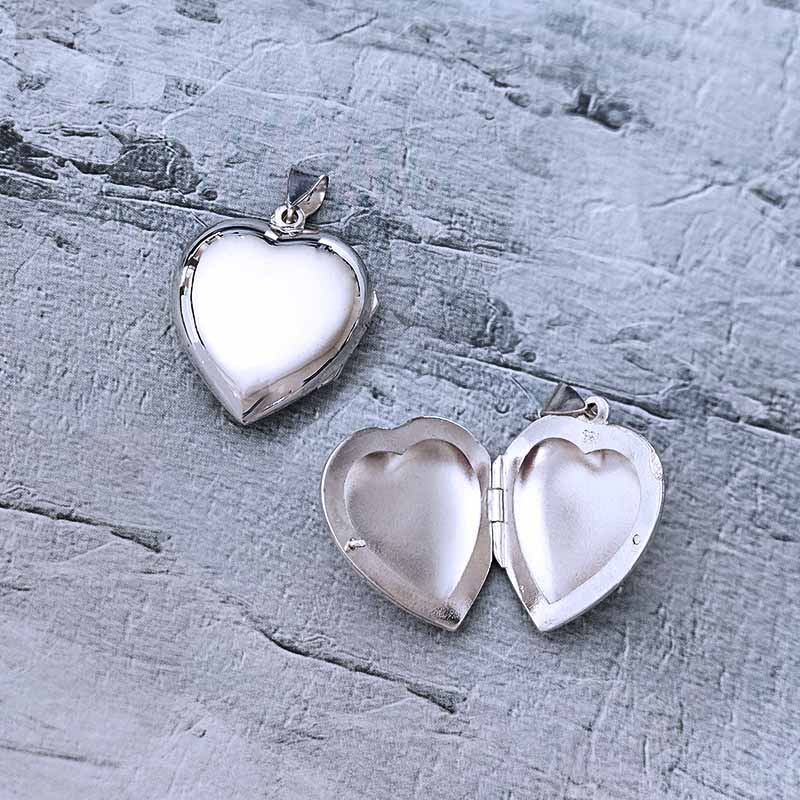 Heart-shaped silver locket on a textured gray surface