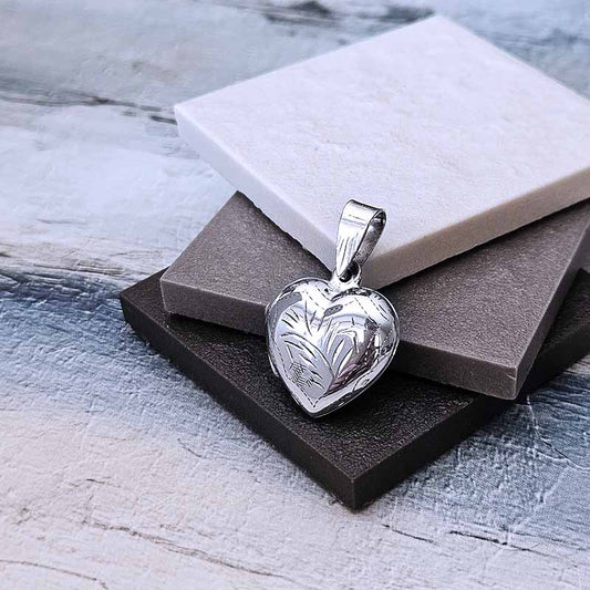 Silver heart-shaped pendant on a textured surface