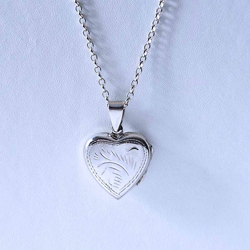 Silver heart-shaped pendant necklace on a light blue background