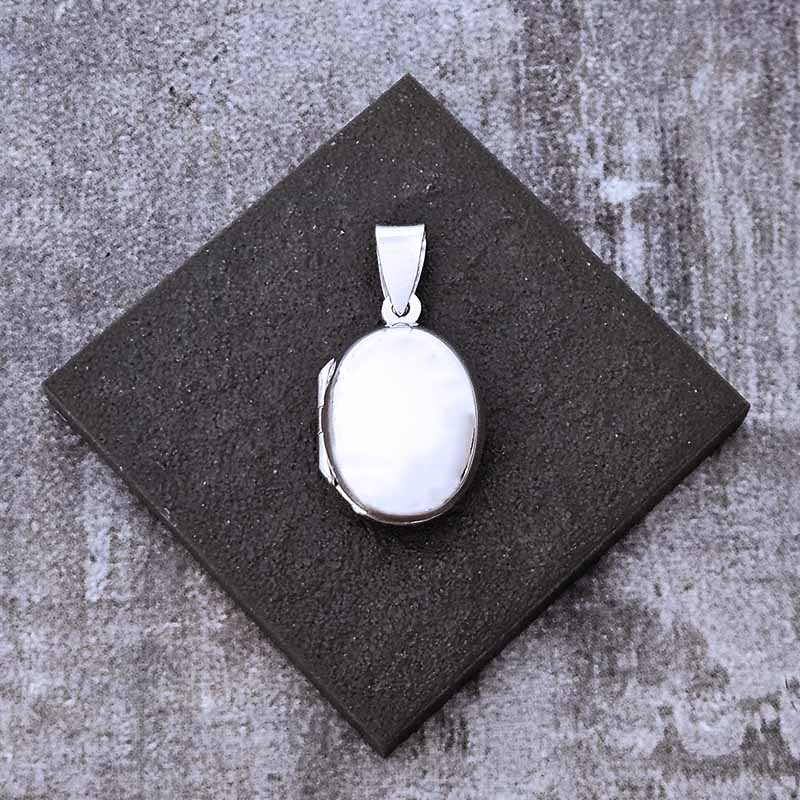 Silver pendant on a dark square stone surface