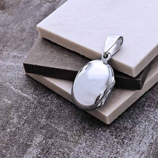 Silver pendant with a white stone on a textured surface