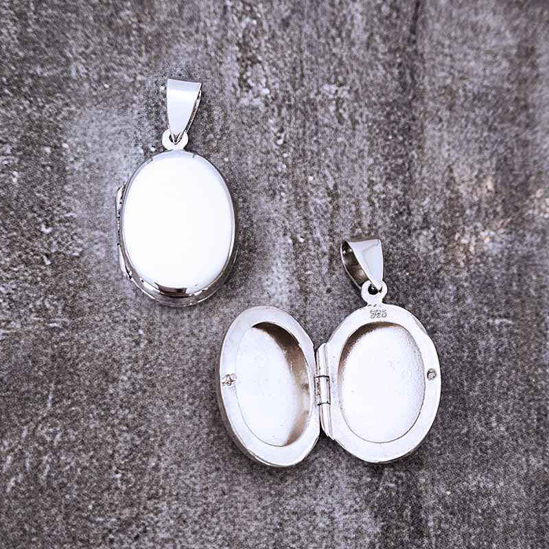 Silver Locket pendant on a stone surface
