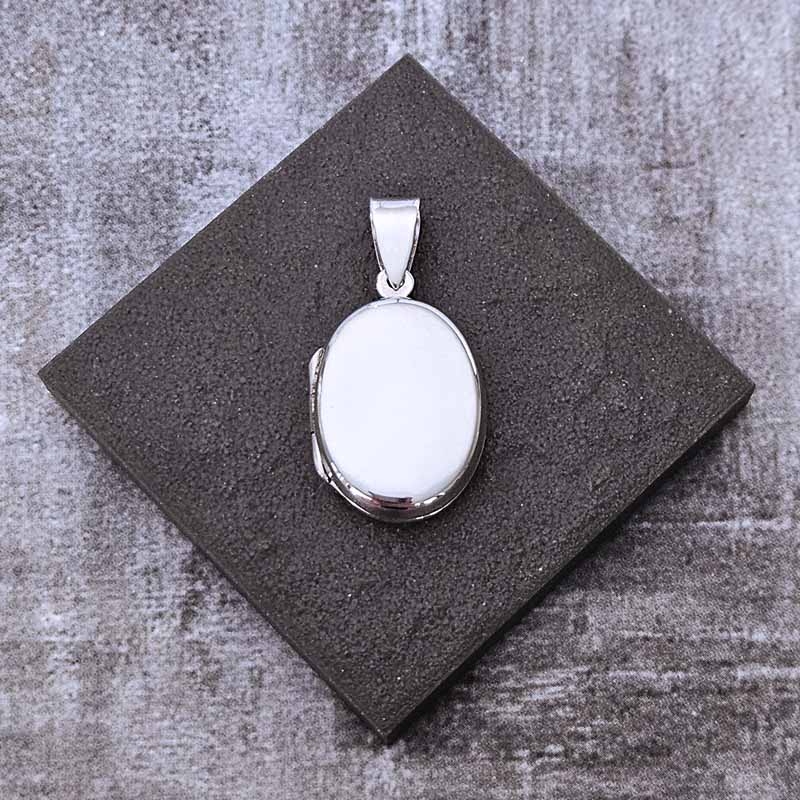 Silver Locket pendant on a stone surface
