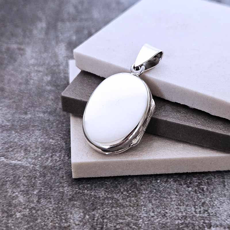 Silver Locket pendant on a stone surface
