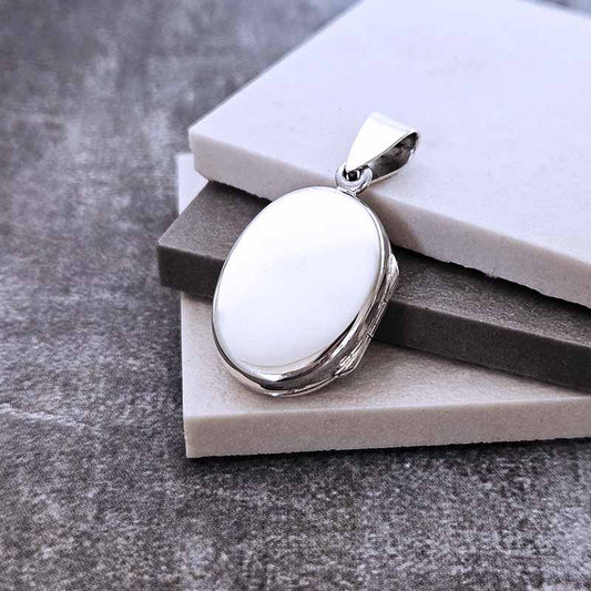 Silver Locket pendant on a stone surface
