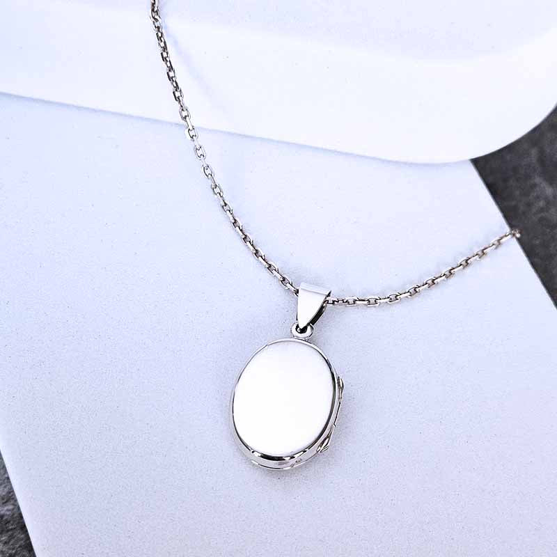 Silver Locket necklace on a stone surface
