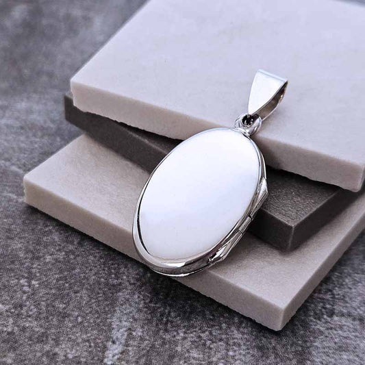 Silver locket pendant on a stone surface