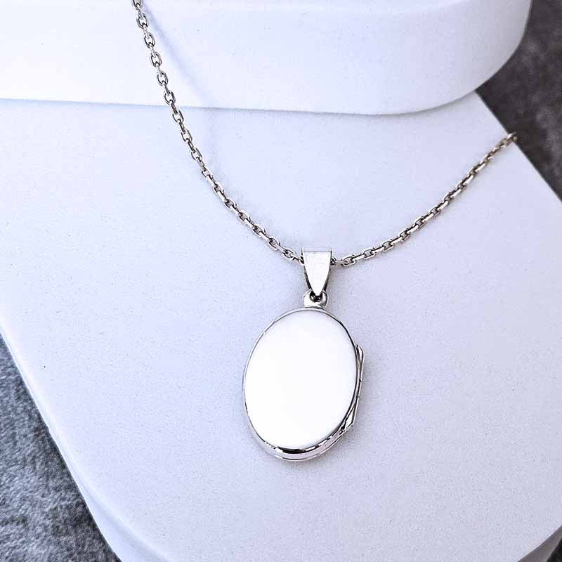 Silver necklace with a pendant on a white surface