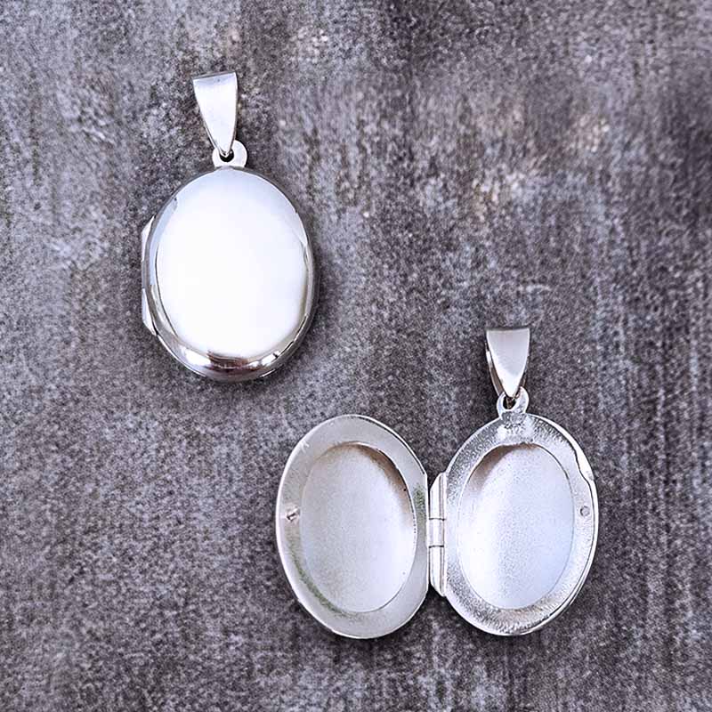Silver oval locket on a textured gray surface