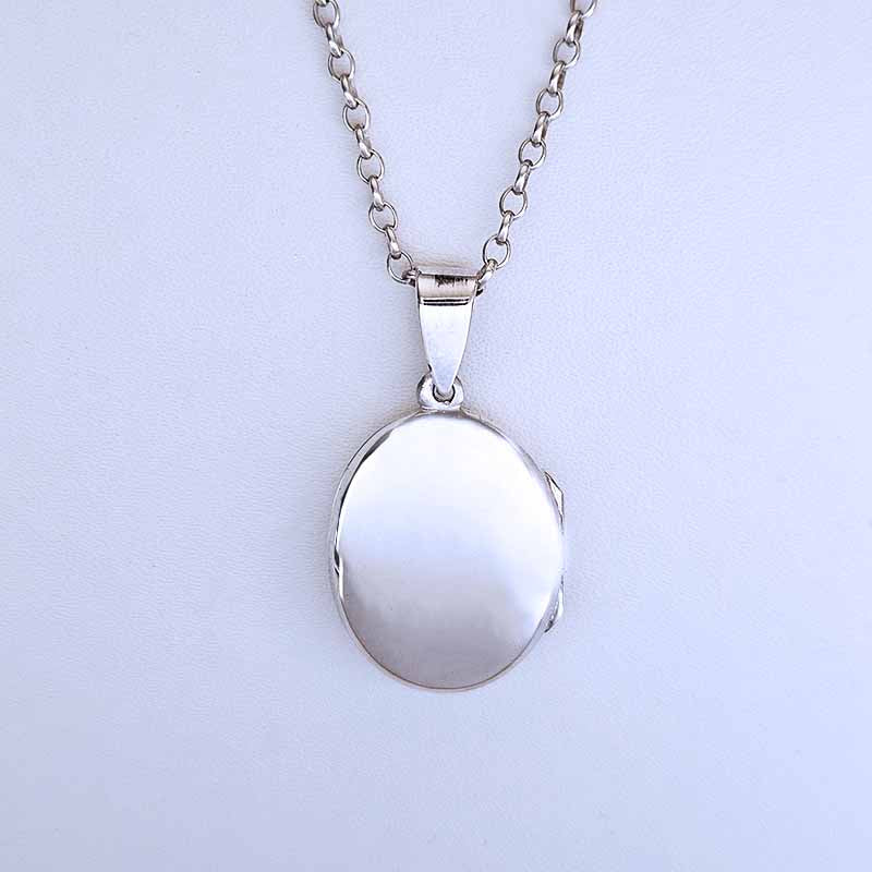 Silver locket necklace on a light gray background