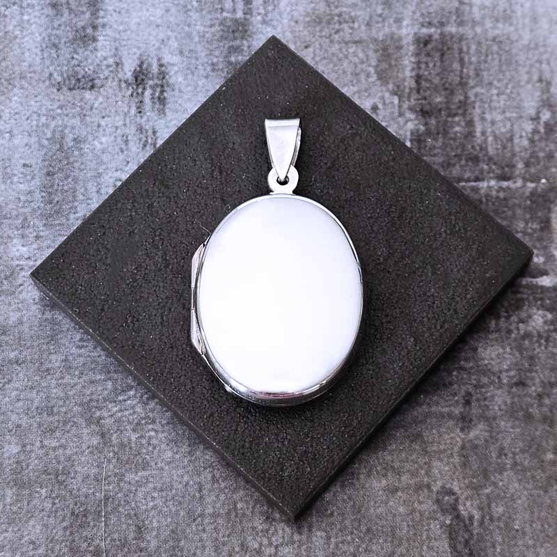 Large Silver Locket pendant with on a dark gray surface