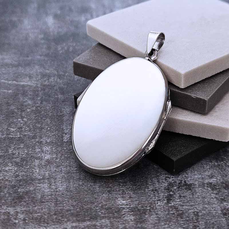 Large Silver Locket pendant with on a gray surface