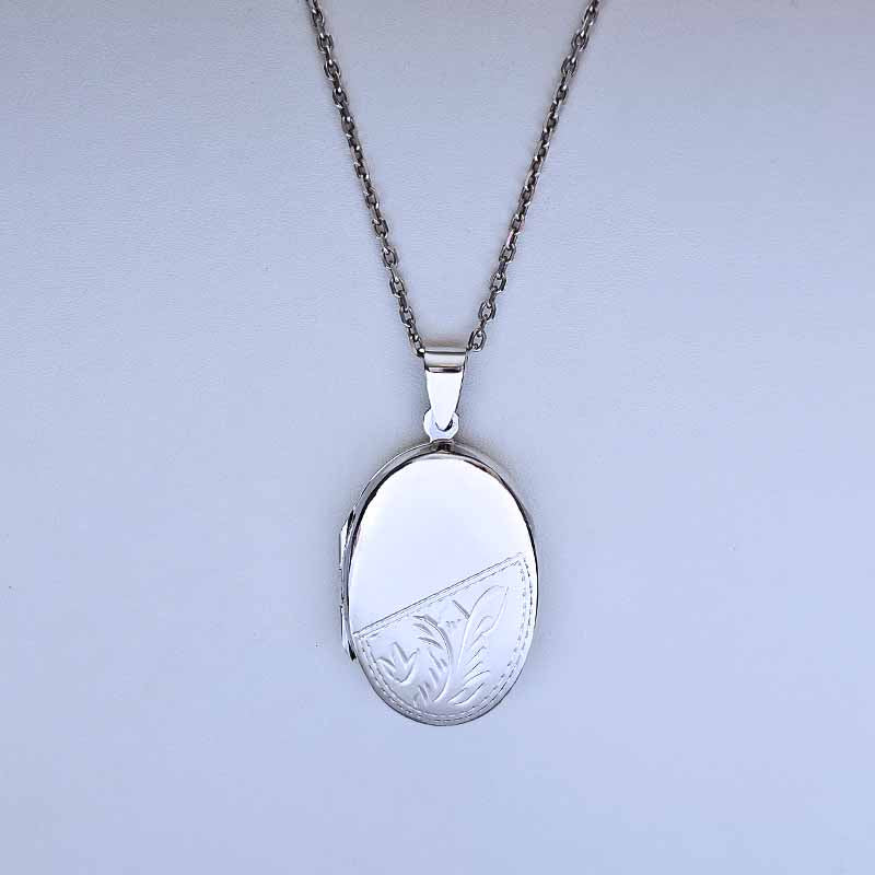 Silver locket with chain on a light gray background