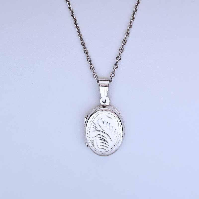 Silver locket necklace on a light gray background