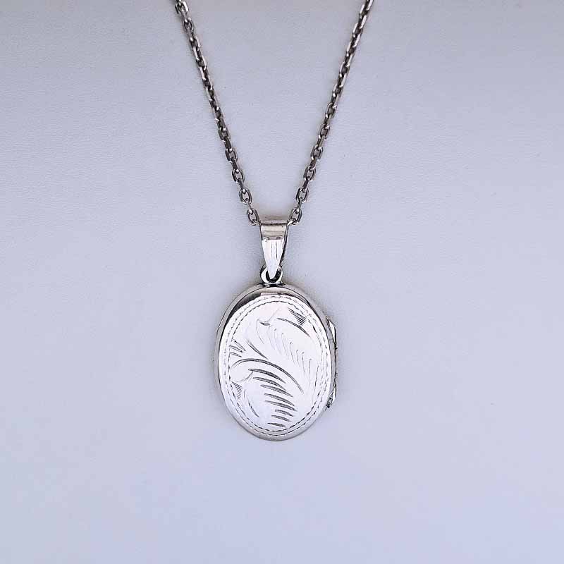 Silver locket necklace on a light gray background