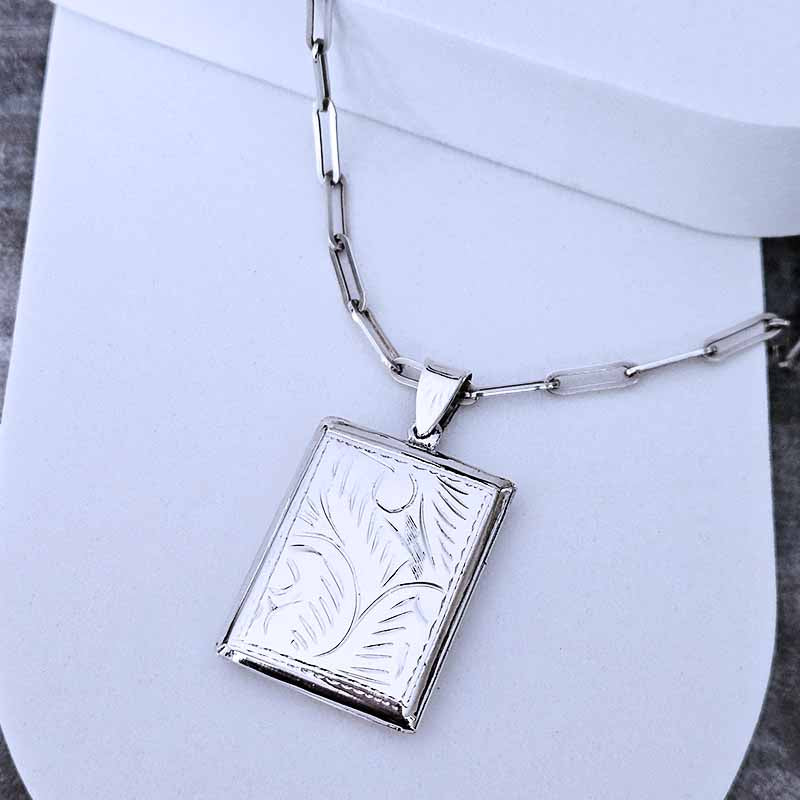 Silver necklace with a rectangular pendant on a white background