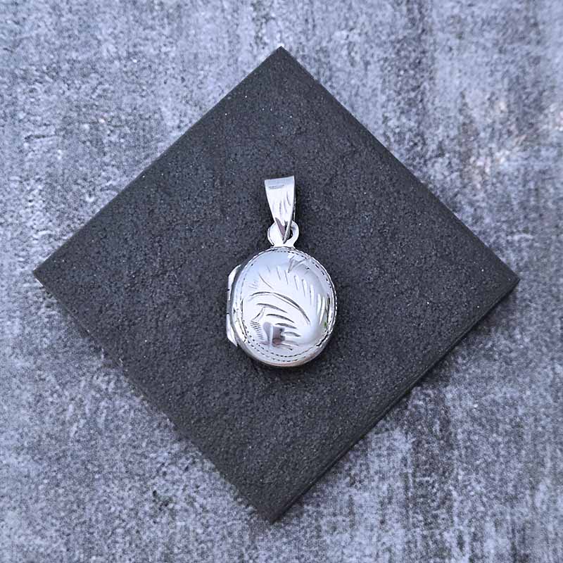 Silver pendant on a black square stone surface