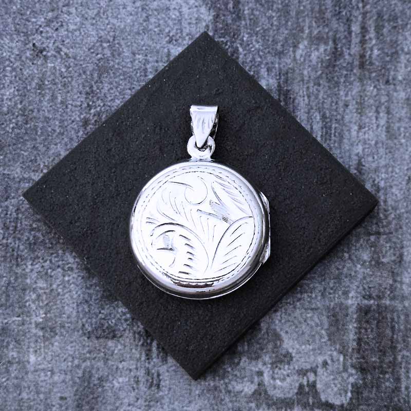 Silver pendant on a black square background