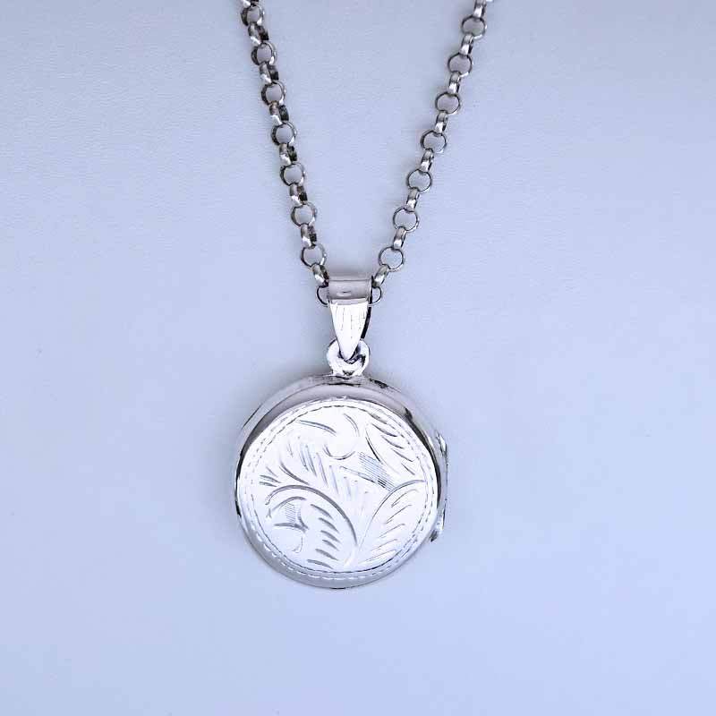 Silver necklace with a round pendant on a light gray background