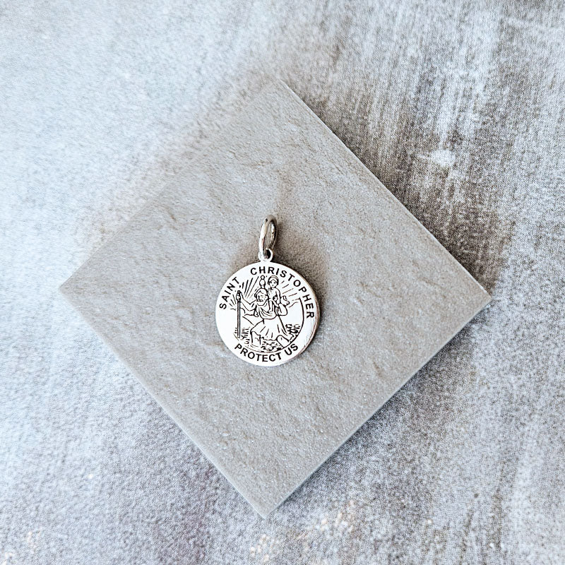 Silver Saint Christopher pendant on a textured beige card