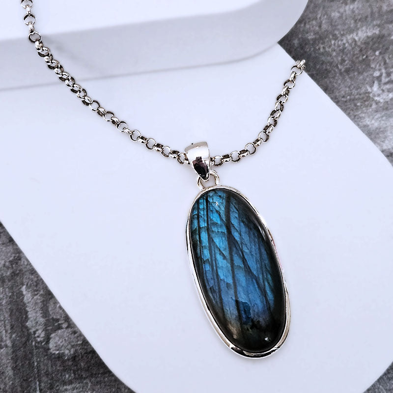 Necklace with a blue pendant on a white stand