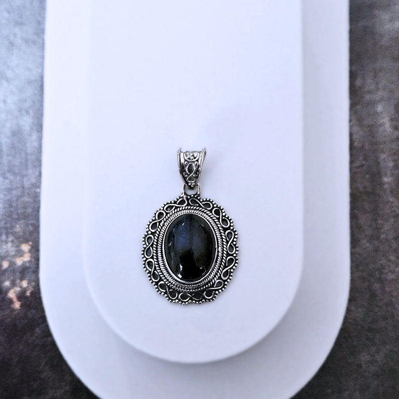 Silver pendant with a Labradorite  stone on a white background