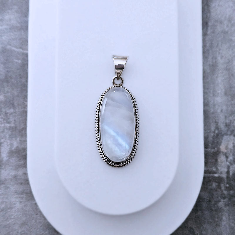 Silver pendant with a light-colored stone on a white background