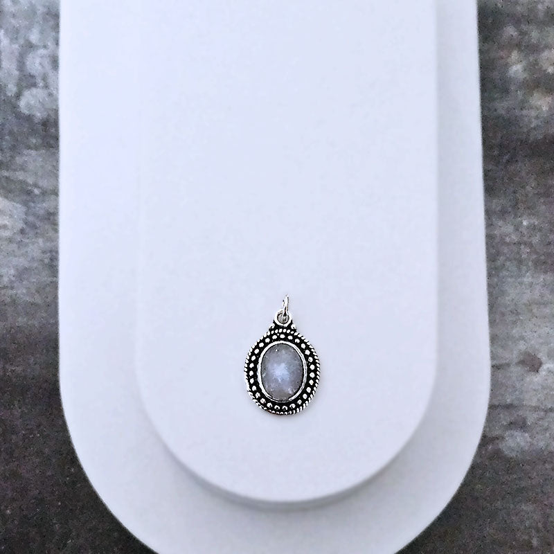 Silver pendant with a central moonstone gemstone on a white background