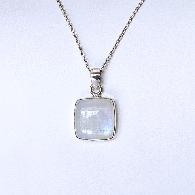 A silver necklace with a square pendant featuring a milky white iridescent stone, shown against a plain white background.