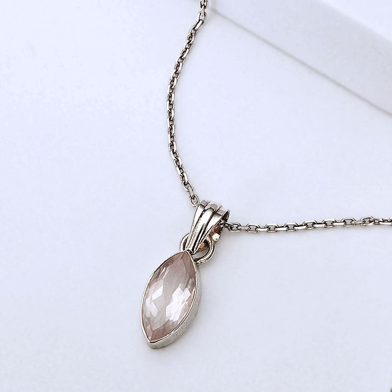 A silver-toned necklace with a faceted marquise-shaped pale pink gemstone pendant, displayed on a clean white background.
