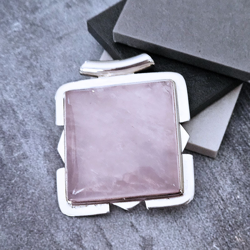Silver-framed pink stone on a gray surface