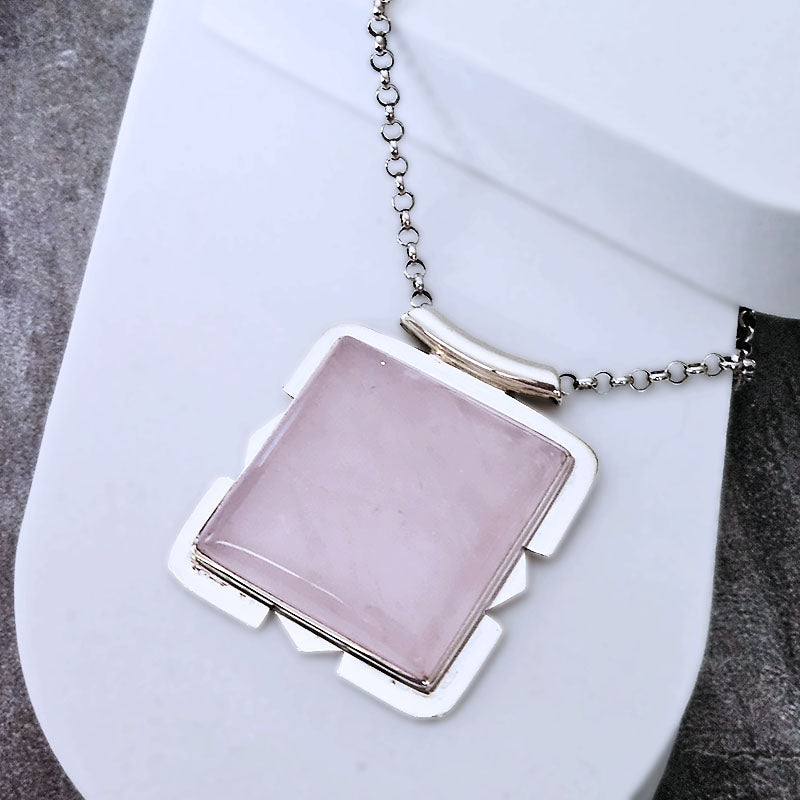 Necklace with a pink pendant on a white surface