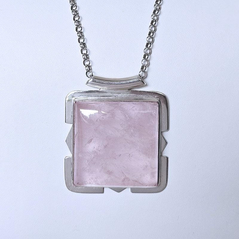 Necklace with a square pink stone pendant on a light gray background