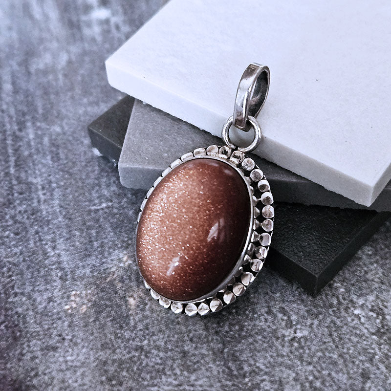 Oval Sunstone set in sterling silver on a marble background