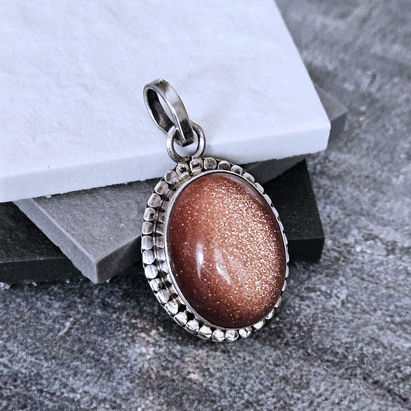 Oval Sunstone set in sterling silver on a marble background