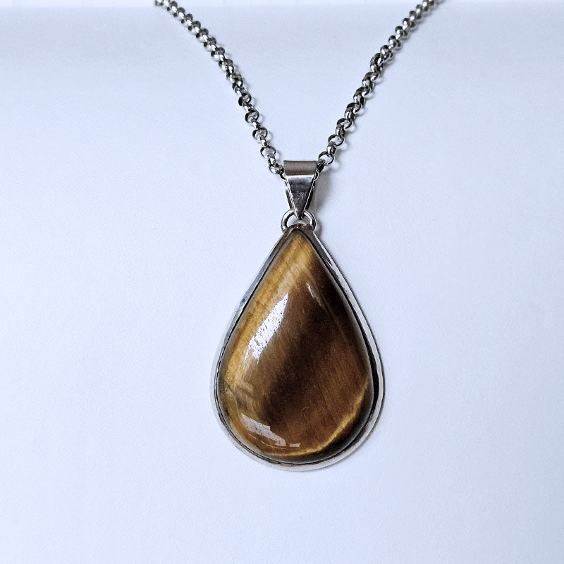 Teardrop-shaped pendant with brown stone on a silver chain against a white background
