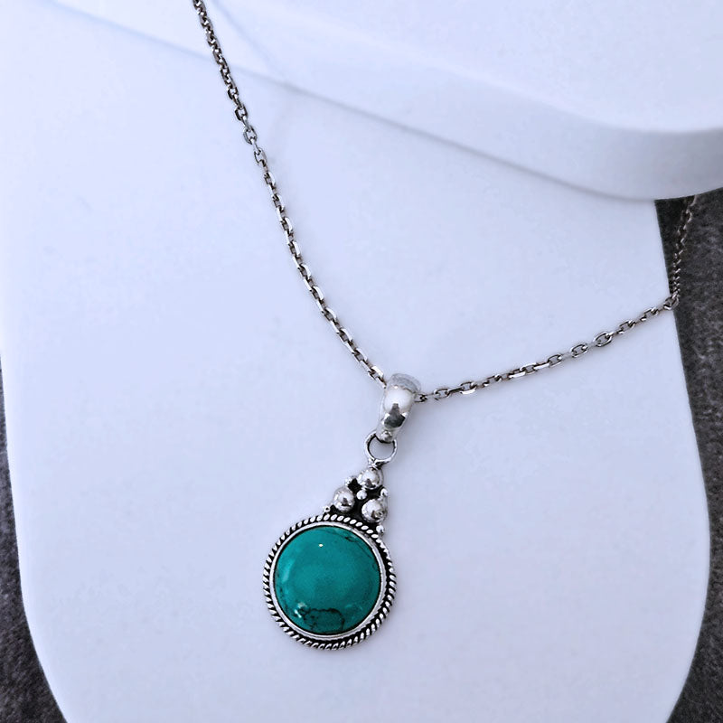 Necklace with a green pendant on a white background