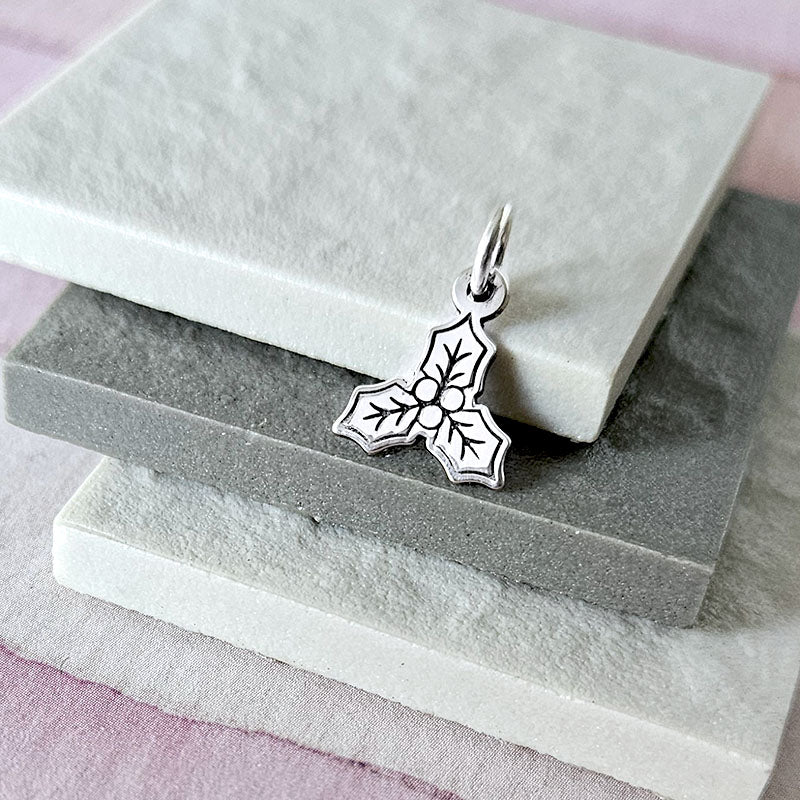Silver mistletoe pendant on a stone surface