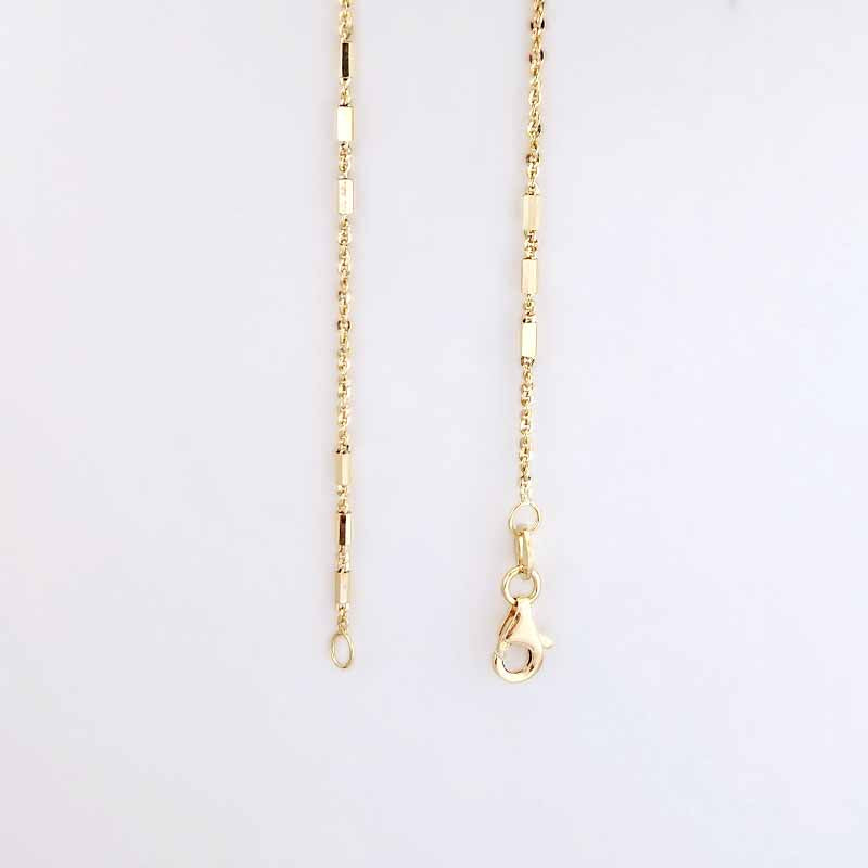 A gold-toned chain necklace with alternating small round beads and elongated rectangular links, shown flat against a plain white background. One end features a lobster clasp.