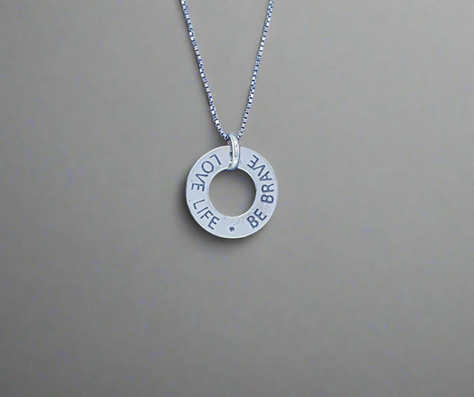 Sterling Silver engraved charm on a silver chain that says love life and be brave