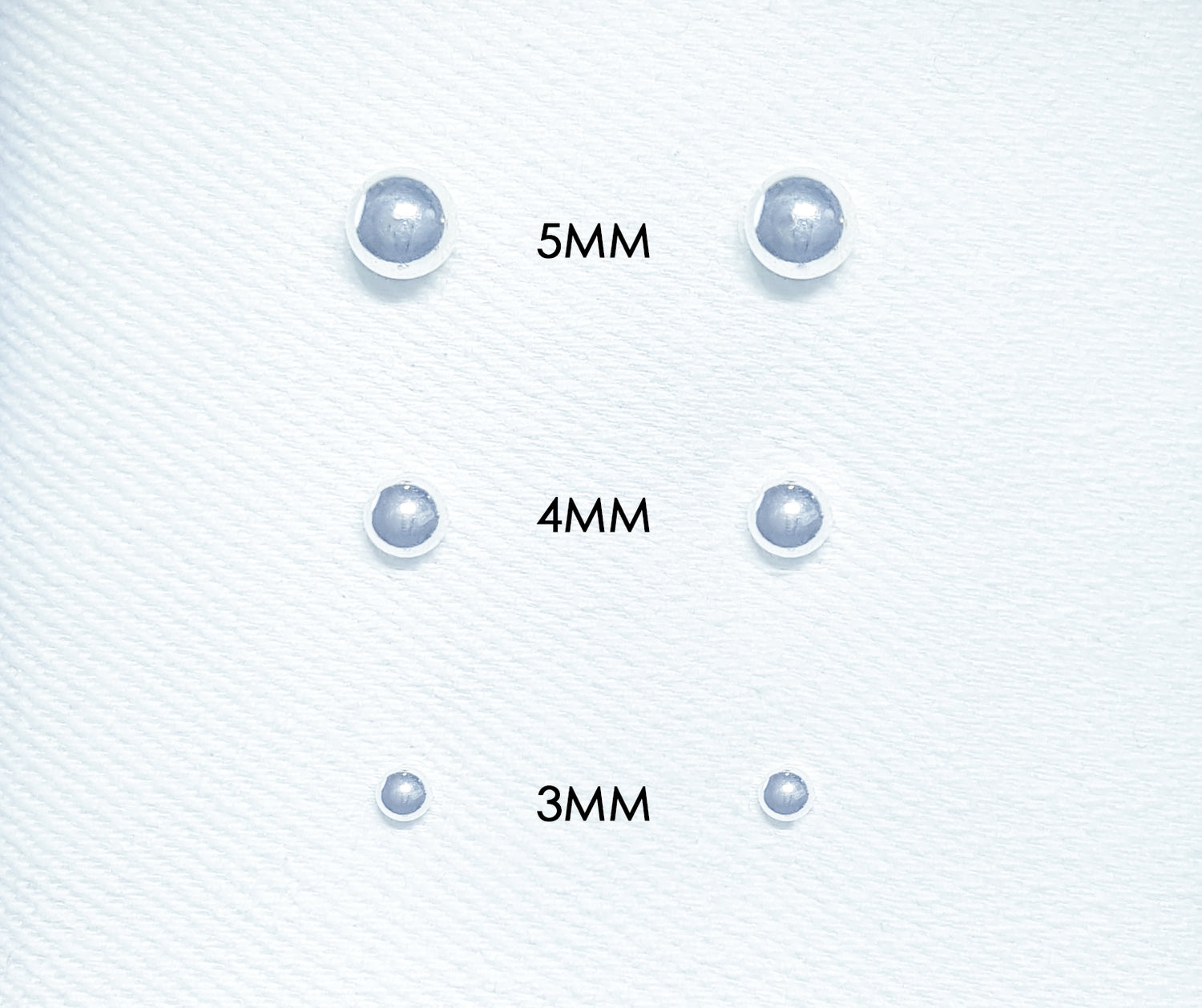 The studs feature small spherical balls made of polished metal or other materials.