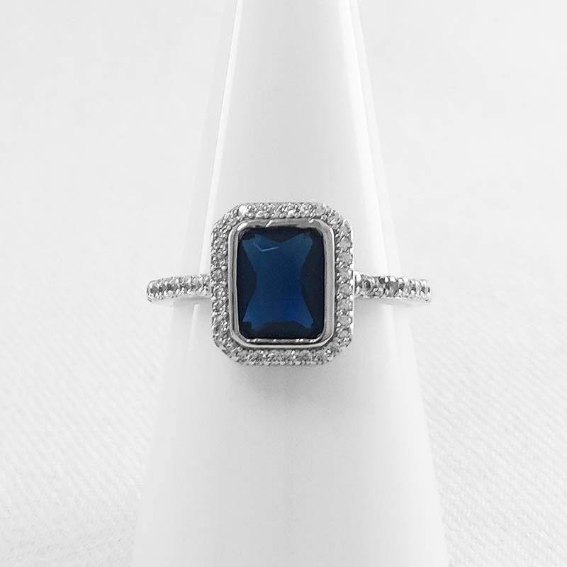 sterling silver ring with a blue rectangle-shaped CZ stone.